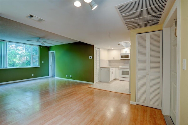 unfurnished living room featuring ceiling fan and light hardwood / wood-style floors