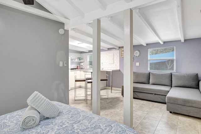 tiled bedroom featuring vaulted ceiling with beams