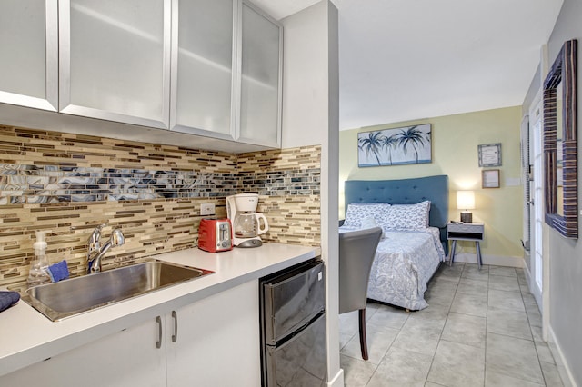 kitchen with light tile floors, white cabinets, tasteful backsplash, and sink