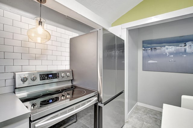 kitchen featuring light tile floors, backsplash, vaulted ceiling, and stainless steel appliances