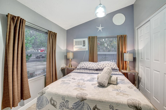 bedroom with vaulted ceiling, a closet, and a wall unit AC