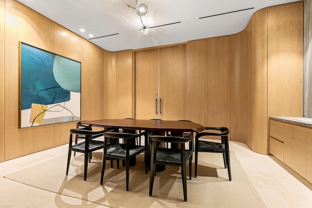 tiled dining room featuring wooden walls