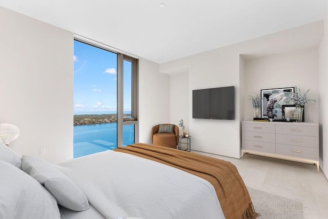 bedroom with access to outside, a wall of windows, and a water view