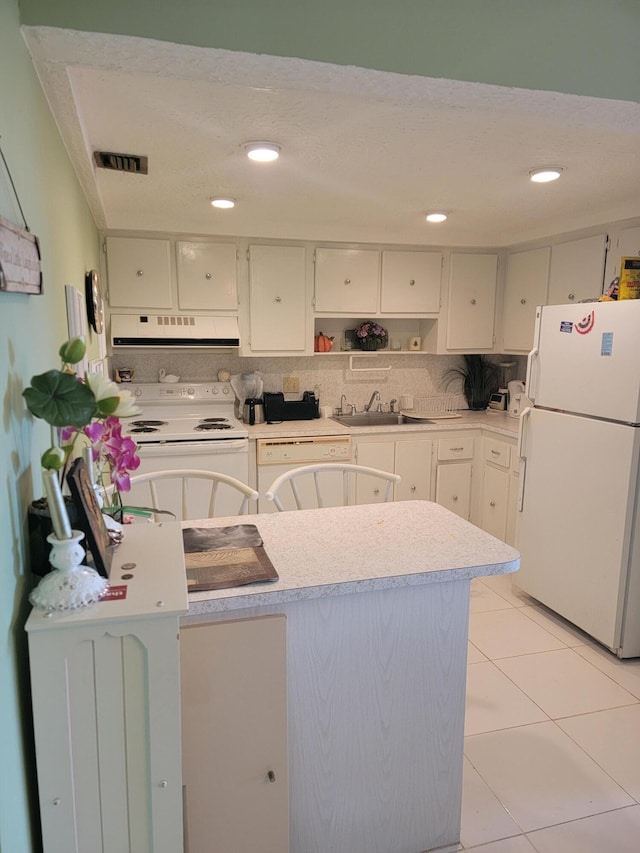 kitchen featuring light tile flooring, tasteful backsplash, white appliances, white cabinetry, and sink