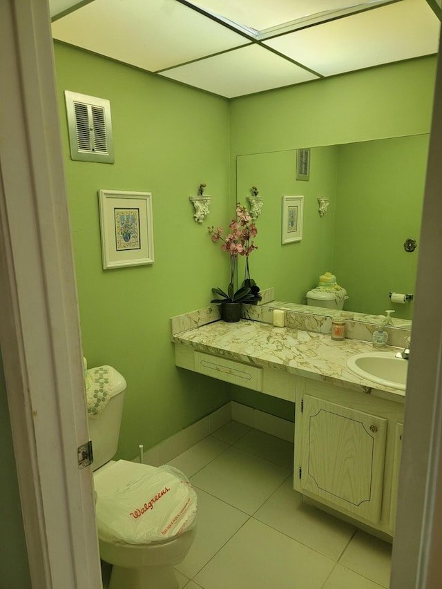 half bath featuring tile patterned flooring, visible vents, vanity, and toilet