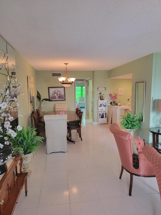 dining room with an inviting chandelier, a textured ceiling, and light tile floors