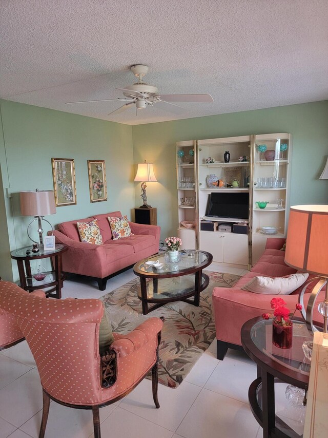 living room with a textured ceiling, ceiling fan, and light tile floors