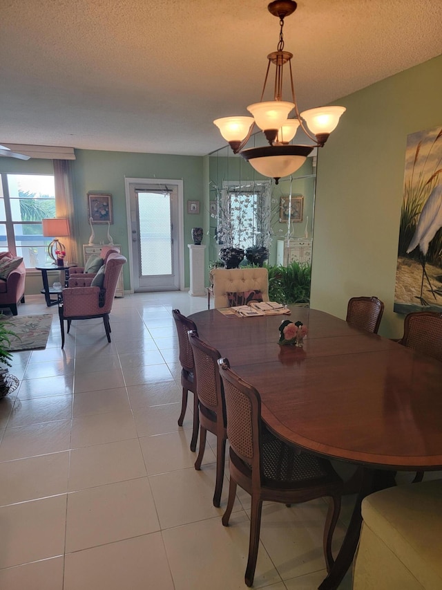 dining space with light tile patterned floors, a chandelier, and a textured ceiling