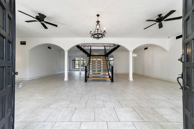 tiled entrance foyer with ceiling fan with notable chandelier