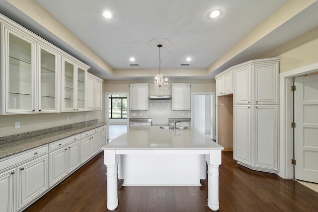 kitchen featuring white cabinets, decorative light fixtures, dark hardwood / wood-style floors, and a breakfast bar area