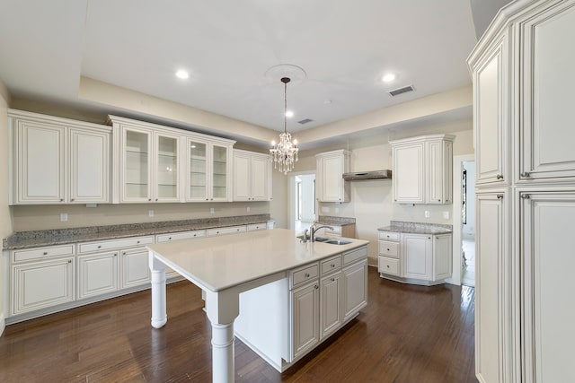 kitchen with a chandelier, dark hardwood / wood-style floors, white cabinetry, and sink