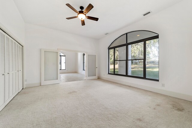 unfurnished room with light colored carpet and ceiling fan