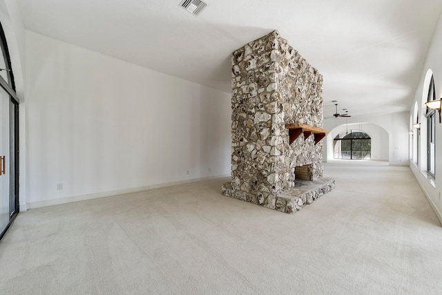 unfurnished living room with light colored carpet and a fireplace