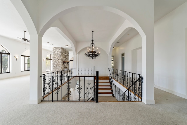 hallway with light carpet and a chandelier