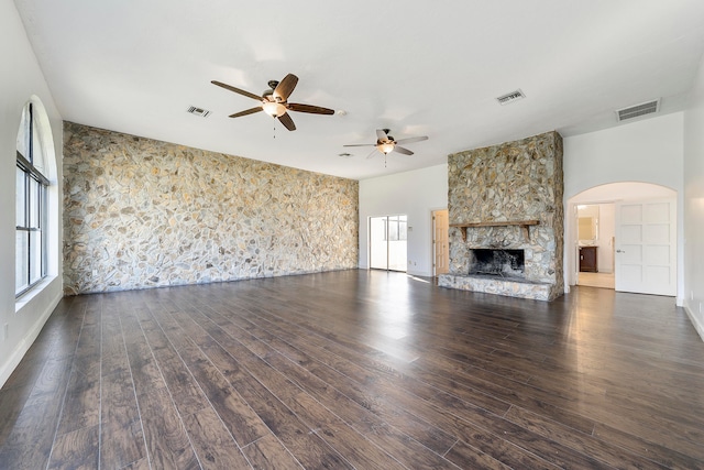 unfurnished living room featuring dark wood-type flooring, ceiling fan, and a fireplace