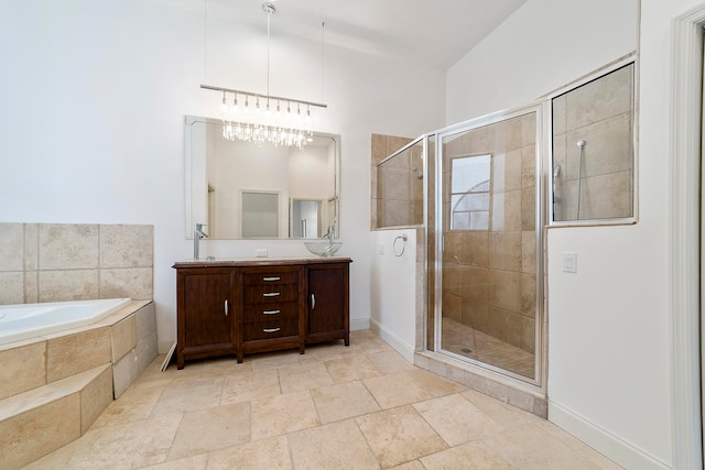 bathroom with tile flooring, plus walk in shower, a notable chandelier, and vanity