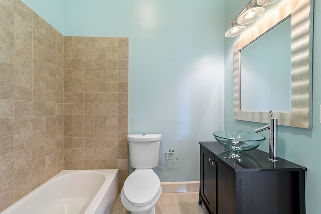 full bathroom with tiled shower / bath, toilet, tile floors, and vanity