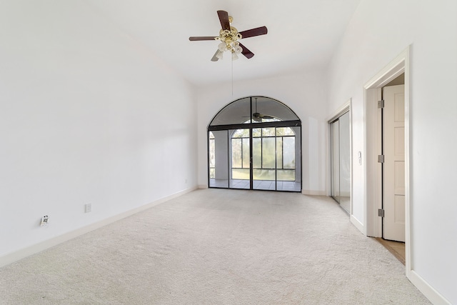 carpeted spare room featuring high vaulted ceiling and ceiling fan