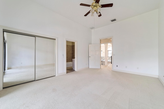 unfurnished bedroom featuring light carpet, ensuite bathroom, and ceiling fan