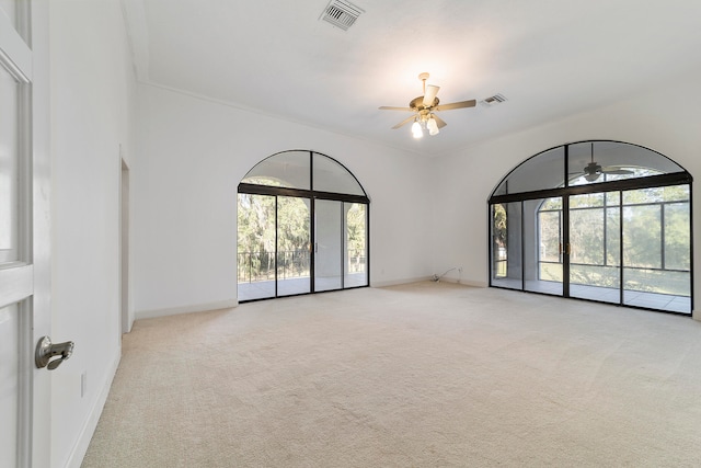 unfurnished room with light colored carpet and ceiling fan