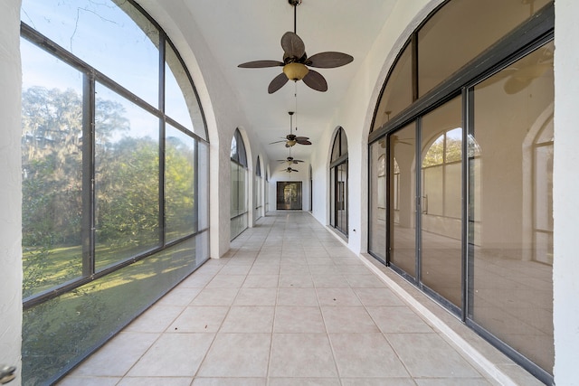 unfurnished sunroom with ceiling fan