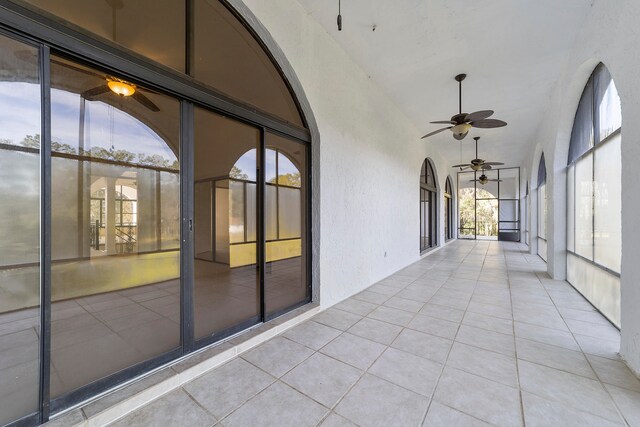 unfurnished sunroom with lofted ceiling and ceiling fan