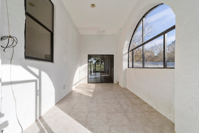 hallway with plenty of natural light and light tile floors