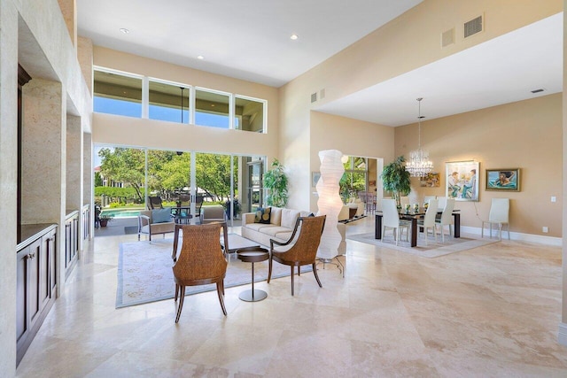 living room featuring an inviting chandelier, a towering ceiling, and light tile flooring