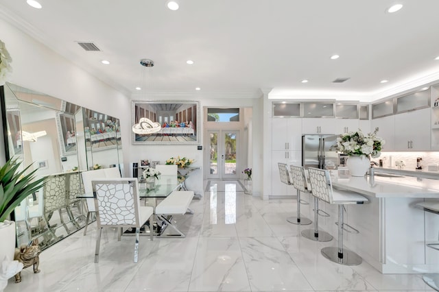 dining space featuring french doors, ornamental molding, and light tile floors