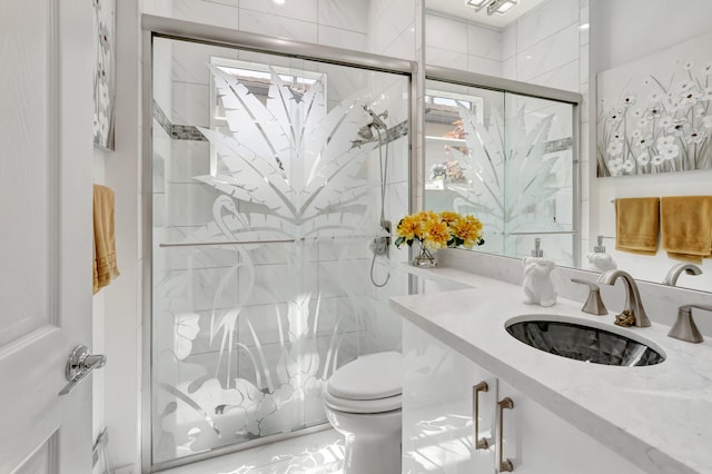 bathroom with sink, a shower with door, and toilet