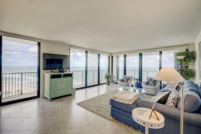 living room featuring a water view, a wall of windows, and light tile floors