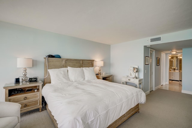 carpeted bedroom featuring ensuite bathroom