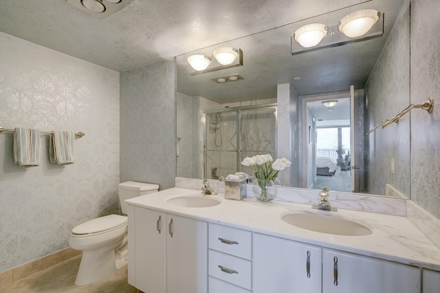 bathroom featuring toilet, dual sinks, and oversized vanity