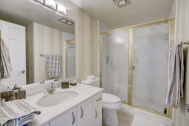 bathroom with toilet, a shower with shower door, vanity with extensive cabinet space, and tile flooring