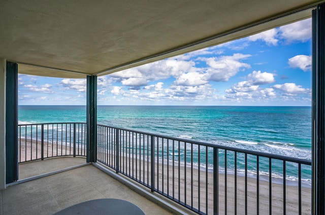 balcony featuring a water view and a beach view