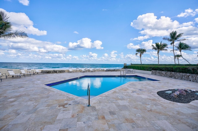 view of pool with a water view and a patio