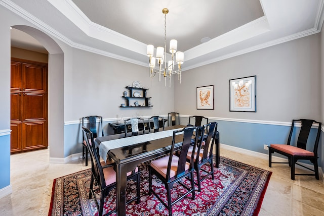 tiled dining area with a chandelier, ornamental molding, and a tray ceiling