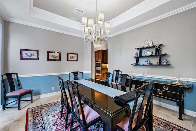 dining area with light tile floors, a chandelier, a tray ceiling, and ornamental molding