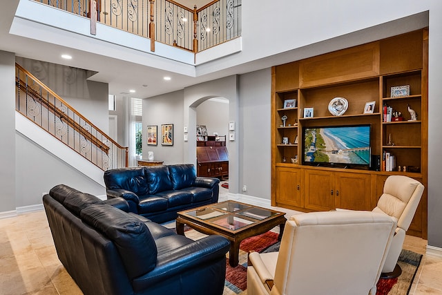 tiled living room featuring built in features and a towering ceiling