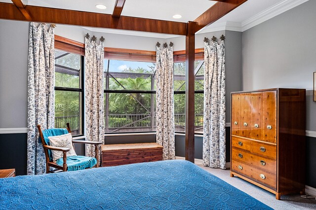 bedroom featuring light carpet, multiple windows, and beamed ceiling