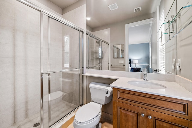 bathroom with a shower with door, large vanity, and toilet