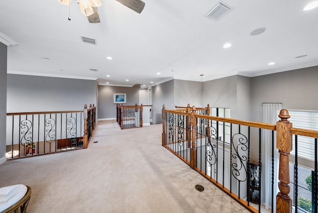 hall with crown molding and light colored carpet