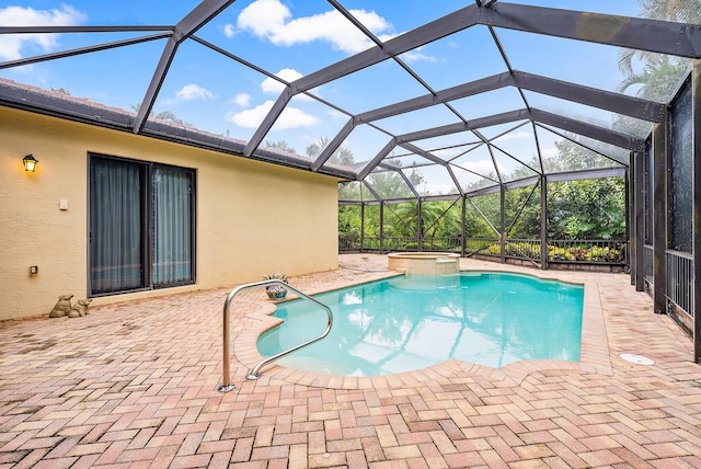 view of pool with an in ground hot tub, glass enclosure, and a patio