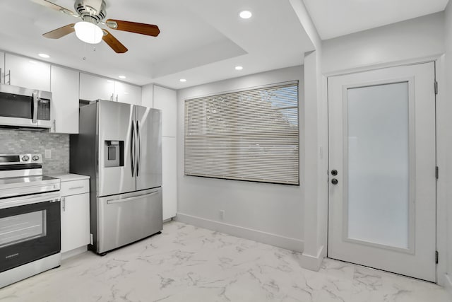 kitchen with white cabinetry, ceiling fan, appliances with stainless steel finishes, light tile floors, and tasteful backsplash