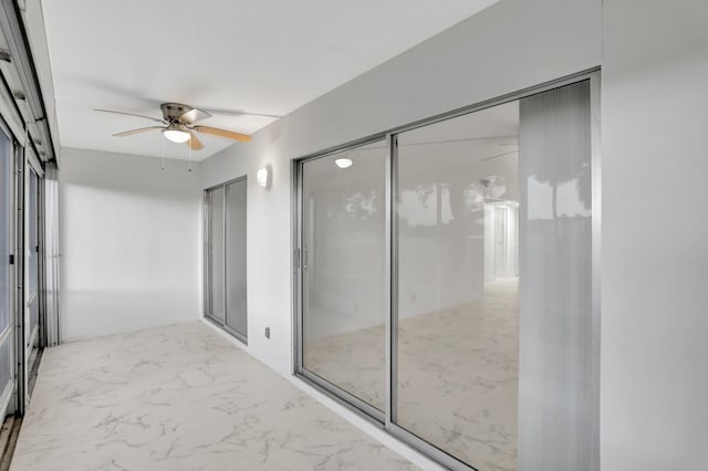 unfurnished sunroom featuring ceiling fan