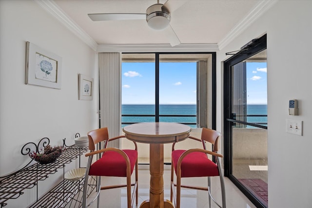 dining area with ceiling fan, a healthy amount of sunlight, and a water view