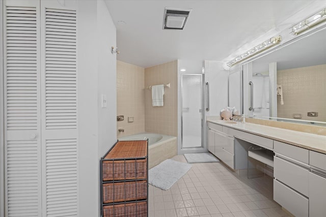 bathroom with shower with separate bathtub, tile floors, and vanity