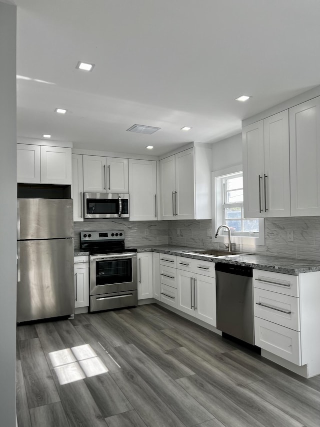 kitchen with hardwood / wood-style flooring, appliances with stainless steel finishes, and sink