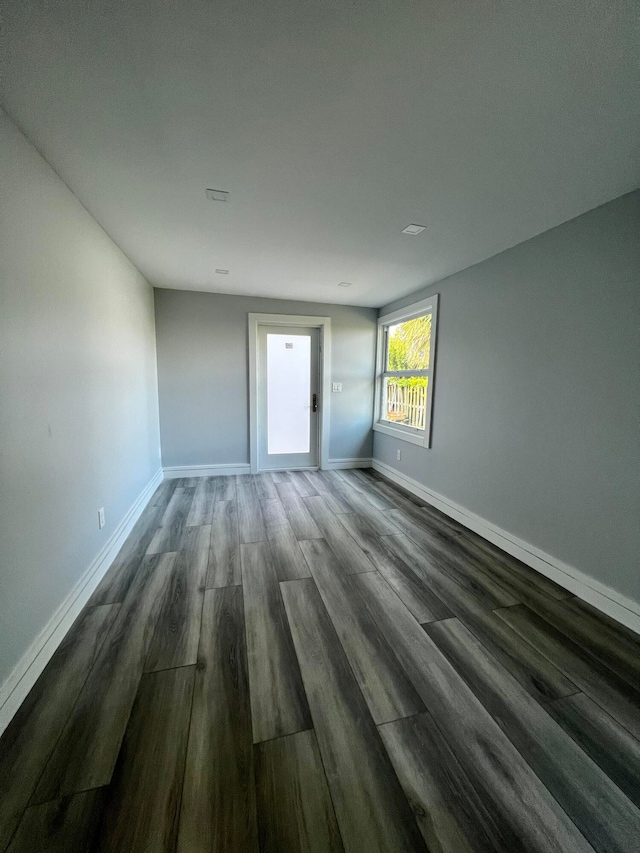 empty room with dark hardwood / wood-style floors