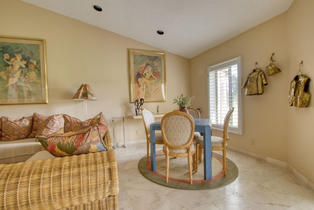 dining space with a textured ceiling and lofted ceiling